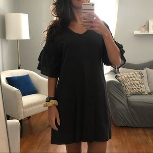 Dark grey dress with ruffle sleeves.